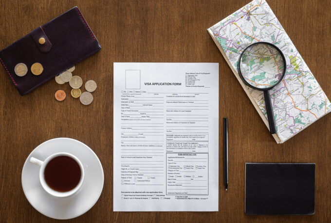 Visa application form on a wooden table, top view, flat lay, visa processing, documentation, immigration.