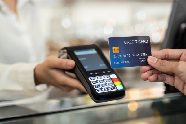 Close up shot of customer hand using dummy credit card for payment to waitress at cashier in cafe restaurant, money cashless and credit card payment technology concept.